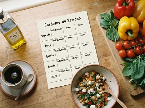 Bancada de cozinha com planner, vegetais frescos e ingredientes